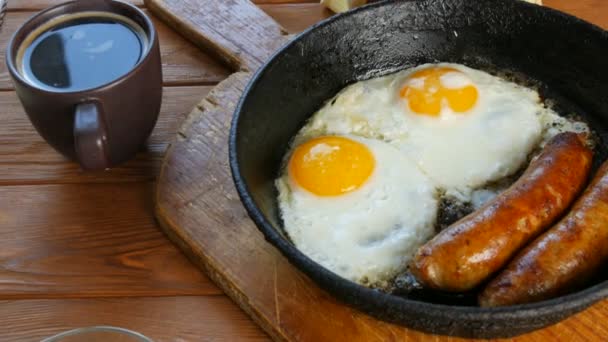 Funny food fried eggs with Bavarian white fried sausages in the form of a face with a smile, next to coffee cup sprinkled with fresh herbs, chopped onions . Rustic style of serving food — Stock Video