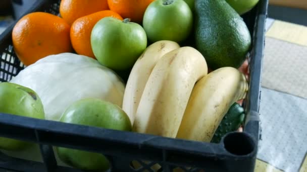 Volle Schachtel mit Obst und Gemüse Bananen Äpfel Mandarinen Avocado Kohl aus nächster Nähe. Essenslieferdienste während der Coronavirus-Pandemie und soziale Distanzierung. Online einkaufen. Essensspenden — Stockvideo