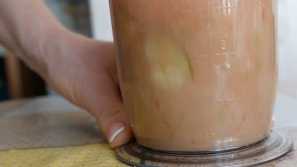 Hand held hand blender in the home kitchen. Womens hands make a healthy red smoothie from bananas, apples and strawberry . Healthy Vegan Food, Raw Food Diet. — Stock Video