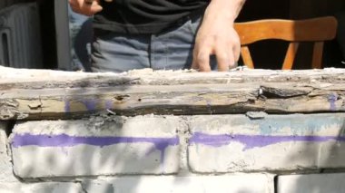 Erkekler eski çürük bir ahşap pencerenin çerçevelerini söker. Eski pencereyi yenisiyle değiştirmek