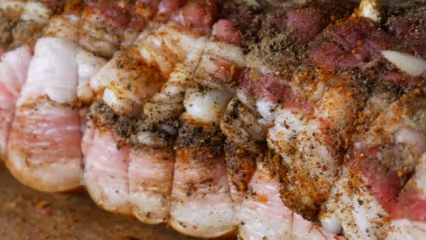 生の肉の豚肉ステーキやベーコンの新鮮なジューシーな作品は、コショウの調味料と,ニンニク,オーブンで焼き糸と素朴なスタイルの巻き戻しでニンジン塩とスパイス,木製の背景に飾る. — ストック動画