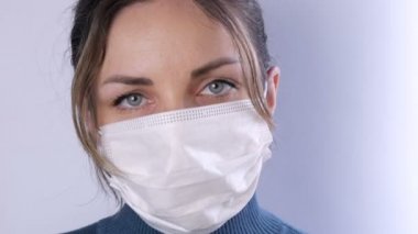 Saçları dağınık, tıbbi maskeli yorgun gözlü, beyaz arka plan görüntüsü olan güzel bir kadın portresi. Hemşireler, salgın sırasında tıbbi personel. Sağlık hizmetleri Coronavirüs ve tıbbi konsept