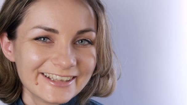 Portrait de belle jeune femme heureuse ou fille aux cheveux courts et aux yeux verts souriants et regardant la caméra sur un fond blanc — Video