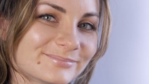 Porträtt av vacker glad ung kvinna eller flicka med kort flödande hår och gröna ögon ler och tittar på kameran på en vit bakgrund — Stockvideo