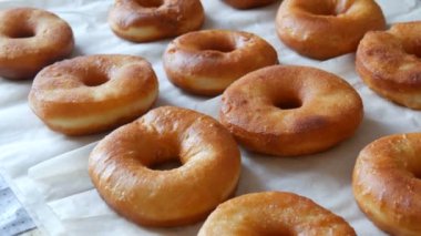 Ev mutfağındaki masada taze kızartılmış büyük yuvarlak çörekler. Jöleli ve tozsuz çörekler.