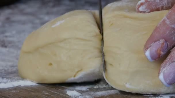 A mão feminina corta a massa com uma faca. Doces caseiros em casa cozinha — Vídeo de Stock