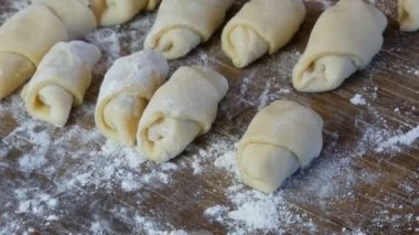 Ev yapımı hamur işleri, taze çörekler, kruvasanlar ve diğer taze hamur işleri ev mutfağındaki masada, fırında pişirmeye hazır.