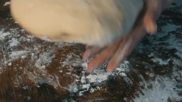 Les mains féminines pétrissent de la pâte fraîche maison sur une planche de cuisine spéciale dans la cuisine de la maison. Pâtisseries maison — Video