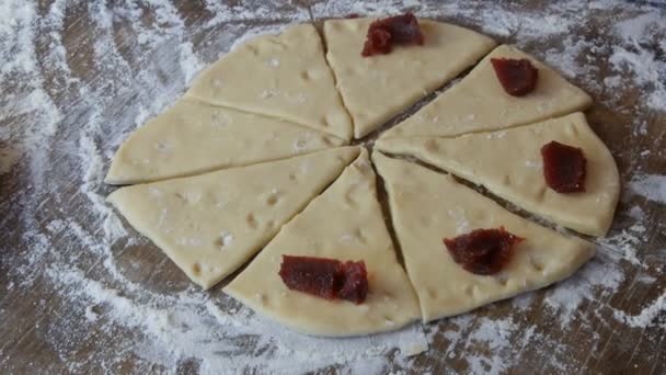 Mermelada de cereza roja en masa fresca, pasteles caseros, una panadera hace bollos de masa en la cocina — Vídeo de stock