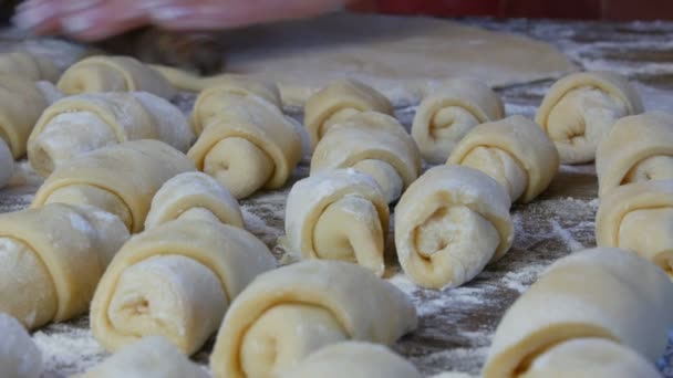 Boulangers mains féminines rouler la pâte avec un rouleau en bois mince dans la cuisine de la maison. Pâtisseries maison fraîches délicieuses . — Video