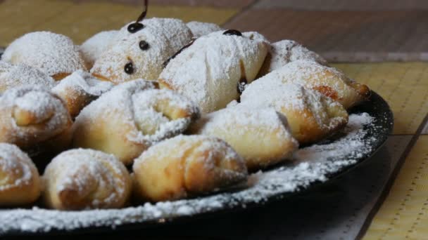 Domácí pečivo, čerstvě upečené croissanty posypané práškovým cukrem a čokoládovou polevou v domácí kuchyni — Stock video