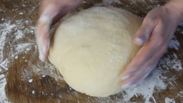 Las manos de las mujeres amasan la masa para hornear en casa chef, pastelería. Panadero amasar la masa en harina sobre la mesa. Pan casero de trigo. Pastelería y Cocina. el concepto de naturaleza, Italia, alimentación, dieta y bio — Vídeo de stock