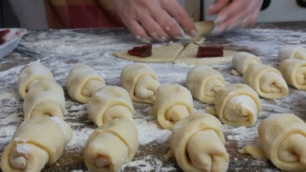 Convierta la masa en forma de croissant. Cruasanes crudos seguidos. Pasteles dulces caseros. Mermelada, la masa, hecha a mano por una mujer. Inicio cocina círculo rebanadas de mermelada de cereza en masa cruda — Vídeos de Stock