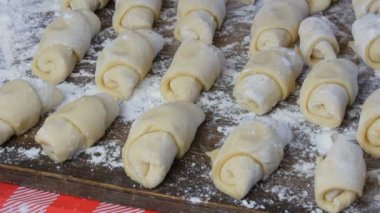 Ev yapımı hamur işleri, taze çörekler, kruvasanlar ve diğer taze hamur işleri ev mutfağındaki masada, fırında pişirmeye hazır.