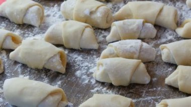 Ev yapımı hamur işleri, taze çörekler, kruvasanlar ve diğer taze hamur işleri ev mutfağındaki masada, fırında pişirmeye hazır.