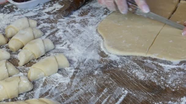 Tangan seorang tukang roti memotong adonan dengan pisau tipis di dapur rumah. Buatan rumah kue-kue segar yang lezat roti dan croissant — Stok Video