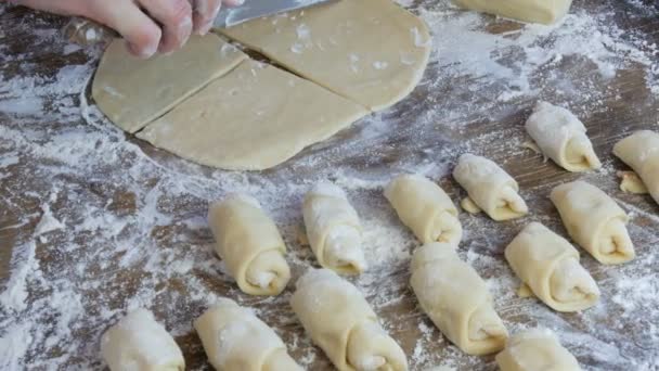 Le mani femminili di un fornaio tagliano l'impasto con un coltello sottile nella cucina di casa. Pasticcini freschi fatti in casa deliziosi panini e croissant — Video Stock