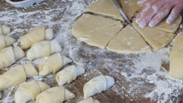 Le mani femminili di un fornaio tagliano l'impasto con un coltello sottile nella cucina di casa. Pasticcini freschi fatti in casa deliziosi panini e croissant — Video Stock