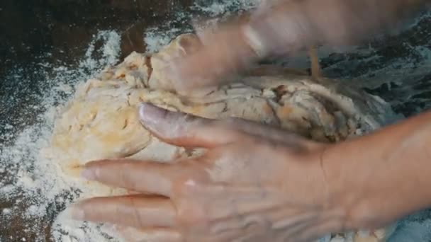 Женские руки месят свежее домашнее тесто на специальной кухонной доске на домашней кухне. Выпечка для дома — стоковое видео