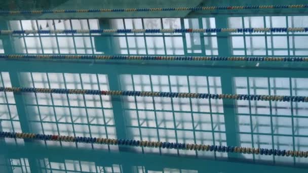 Piscina vazia com reflexão calma da luz do dia da água e água limpa e pista para natação. Água azul na piscina. Caminhos vazios com faixas raciais — Vídeo de Stock