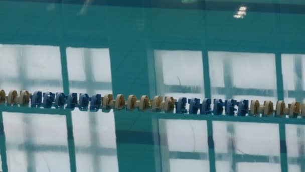 Leeres Schwimmbad mit ruhigem Wasser, Tageslichtreflexion und klarem Wasser und Schwimmstrecke. Blaues Wasser im Schwimmbad. Leere Wege mit Rennspuren — Stockvideo