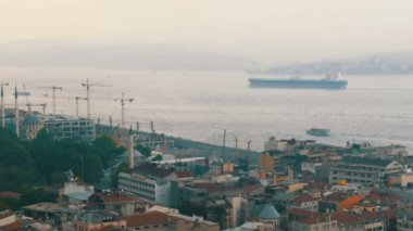 Güzel İstanbul 'un panoramik manzarası. Köprü, gemiler, çatılar, arabalar, evler, gökyüzü. Dünyaca ünlü Galata Kulesi 'nin tepesinden bak.