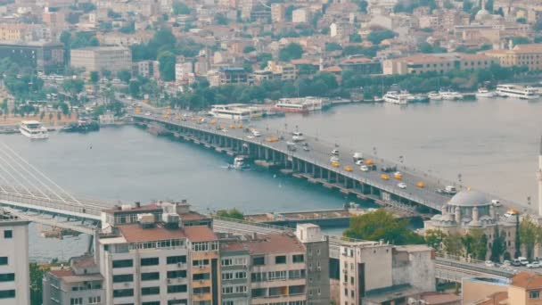Grote brug over het kanaal waar gele taxi 's doorheen rijden. Panoramisch uitzicht op het prachtige Istanbul. Luchtfoto vanuit de Galata toren — Stockvideo