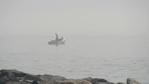 Силует рибалки який рибалить у морі на човні — стокове відео