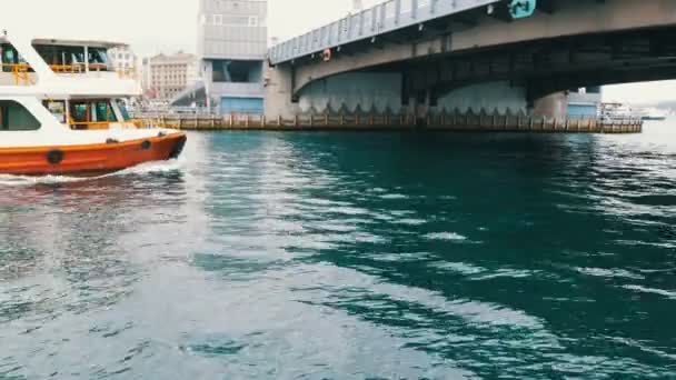 Estambul, Turquía - 11 de junio de 2019: 11 de junio de 2019: barco turístico navegando bajo un puente en el Mar de Mármara. Vista desde el muelle de Eminenu — Vídeos de Stock