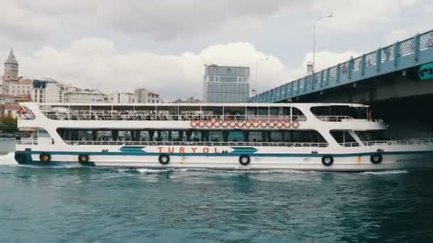 Estambul, Turquía - 11 de junio de 2019: 11 de junio de 2019: barco turístico navegando bajo un puente en el Mar de Mármara. Vista desde el muelle de Eminenu — Vídeos de Stock