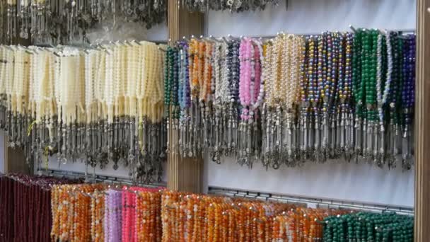 Multi-gekleurde kralen van verschillende natuurstenen hangen in een juwelier in Istanbul. Kleurrijke kralen kettingen modieuze vrouwen statement sieraden — Stockvideo