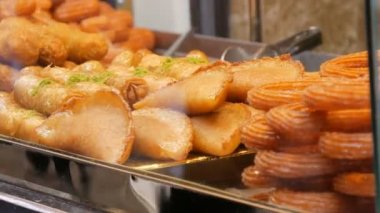 Bir sokak dükkanının tezgahında çeşitli yağlı hamur işleri var. Fast Food, Street Junk Food