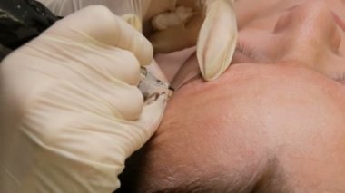 Kalıcı makyaj için iğnesi olan kalem, usta eller güzellik salonundaki kaş şeklini düzeltir. Barut püskürtme ile modern düzeltme yöntemi. Mikroplu patinaj, kaş dövmesi