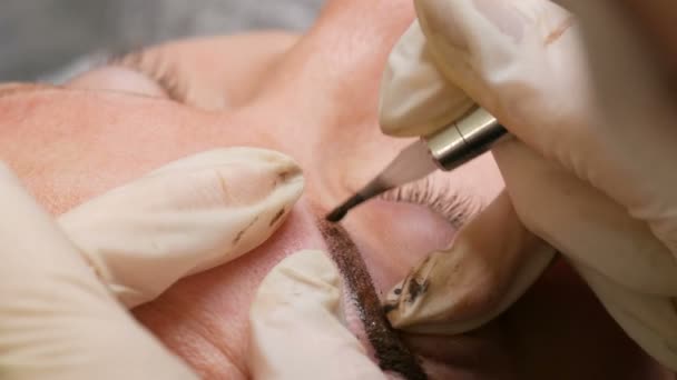 Îmbunătățirea și corectarea formei sprâncenelor în salonul de frumusețe. O metodă modernă de corecție a sprâncenelor cu pulverizare cu pulbere. Microblading, tatuaj sprâncene, machiaj permanent — Videoclip de stoc