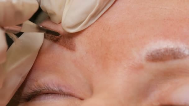 Melhorar a forma das sobrancelhas em uma visão de close-up de salão de beleza. Microblading, maquiagem permanente, maquiagem permanente, pulverização em pó — Vídeo de Stock