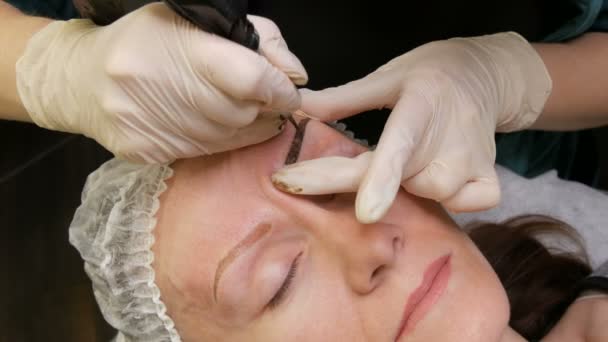 Stift mit Nadel für Permanent-Make-up, die Meisterhände korrigieren im Schönheitssalon die Form der Augenbrauen. Moderne Korrekturmethode mit Pulversprühen. Microblading, Augenbrauen-Tätowierung — Stockvideo