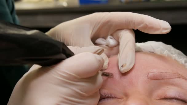 Förbättra och korrigera formen på ögonbrynen i skönhetssalongen. En modern metod för ögonbrynskorrigering med pudersprutning. Mikroblades, ögonbrynstatuering, Permanent makeup — Stockvideo