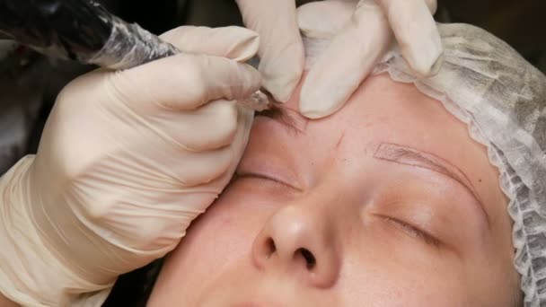 La mano del maestro hace el maquillaje permanente. Un método moderno de corrección de cejas con pulverización en polvo. Microblading, tatuaje de la ceja — Vídeos de Stock