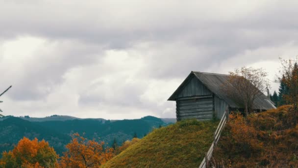 Gamla trä övergivna trähus för herdar på bakgrund av pittoreska Karpatiska bergen på hösten. Övergiven byggnad i dåligt skick — Stockvideo