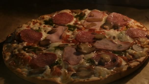 Delicious pizza with mushrooms, salami, bacon, herbs, and cheese is cooked in oven — Stock Video