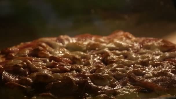 Italiaanse pizza met plakjes salami, waarop thuis kaas wordt gesmolten, gebakken in een oven. — Stockvideo
