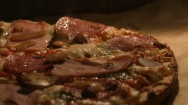 Mantarlı, salamlı, pastırmalı, otlu ve peynirli lezzetli pizza fırında pişiriliyor.