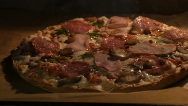 Delicious pizza with mushrooms, salami, bacon, herbs, and cheese is cooked in oven — Stock Video