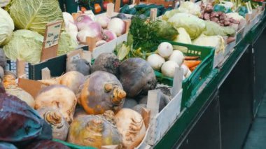 Çok çeşitli meyveleri olan sebze ve meyve pazarı. Sağlıklı vejetaryen yemekleri. Büyük şehirde sebze pazarı. Tezgahta sağlıklı taze organik vegan yiyecekler var. Fiyat etiketleri Almanca.