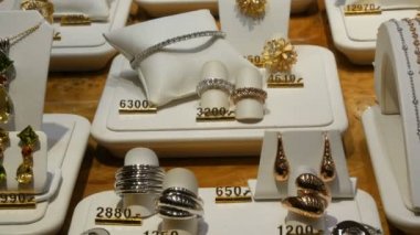 Mücevher dükkanının tezgahında pahalı seçkin mücevherler var. Çeşitli elmaslar, safir küpeler, bilezikler, yüzükler, fiyat etiketli kolyeler.