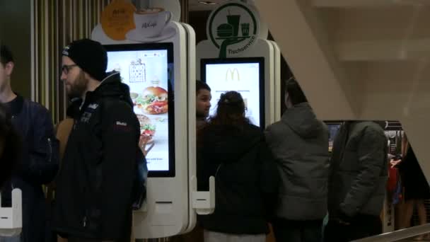 Відень, Австрія - 19 грудня 2019: Цифровий екран для замовлень без касирів на McDonalds. Люди роблять порядок швидкого харчування за допомогою цифрового екрану. Сучасні технології без операторів — стокове відео