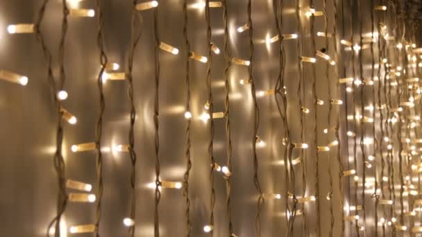 Brillante guirnalda blanca de Navidad eléctrica en una fila en la pared. Decoración de Navidad. Fondo abstracto para las luces led navideñas — Vídeos de Stock