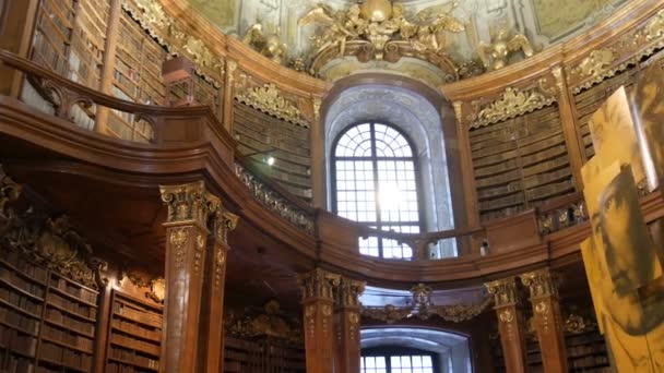 Bécs, Ausztria - 2019. december 23.: Az Osztrák Nemzeti Könyvtár belseje több régi évkönyvvel a polcokon. Ausztria legnagyobb könyvtára. Található a Hofburg Palace. — Stock videók