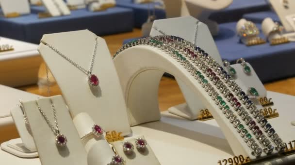 Expensive elite jewelry on the counter of jewelry store. Various diamonds, sapphires, white gold in earrings, bracelets, rings, necklaces with price tags — 비디오