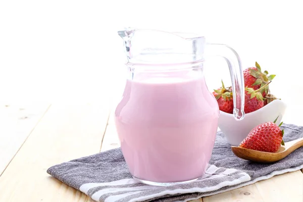 Taze çilek süt eski bir ahşap masa üzerinde yapılmış.